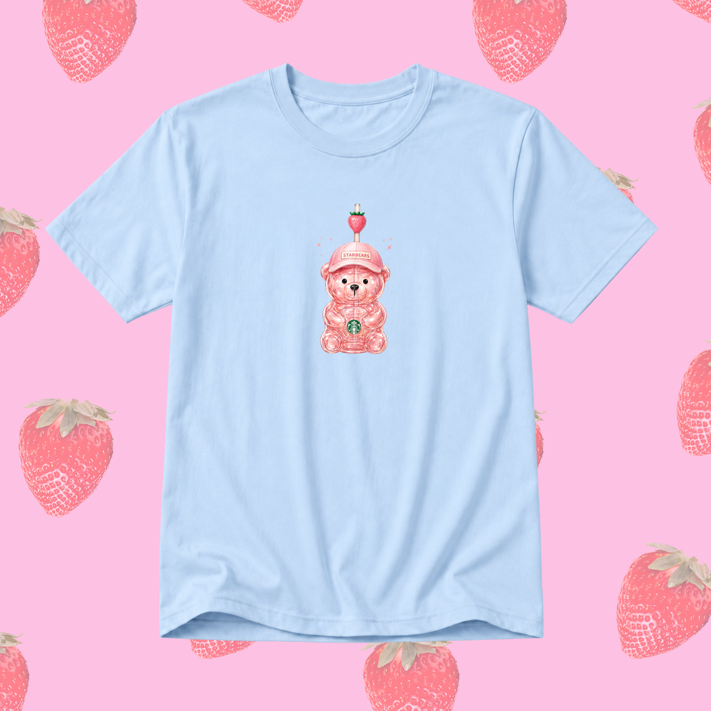 A light blue short-sleeve t-shirt featuring a cute pink cartoon teddy bear wearing a strawberry hat in the center. The t-shirt is displayed flat against a pink background patterned with illustrated strawberries.