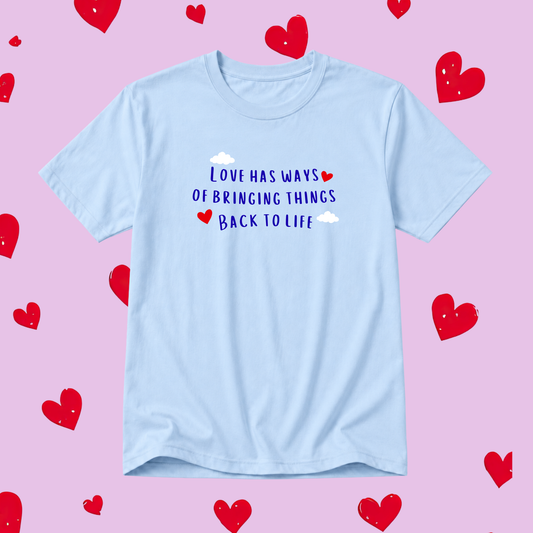 Light blue t-shirt with motivational quote on a pink background with red hearts