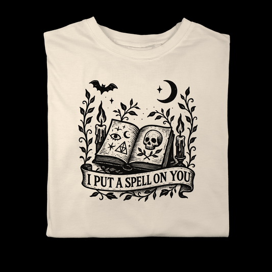 Vintage gothic illustration of an open spellbook with candles, bats, vines, and a ribbon reading ‘I Put a Spell on You’, black ink on parchment background.