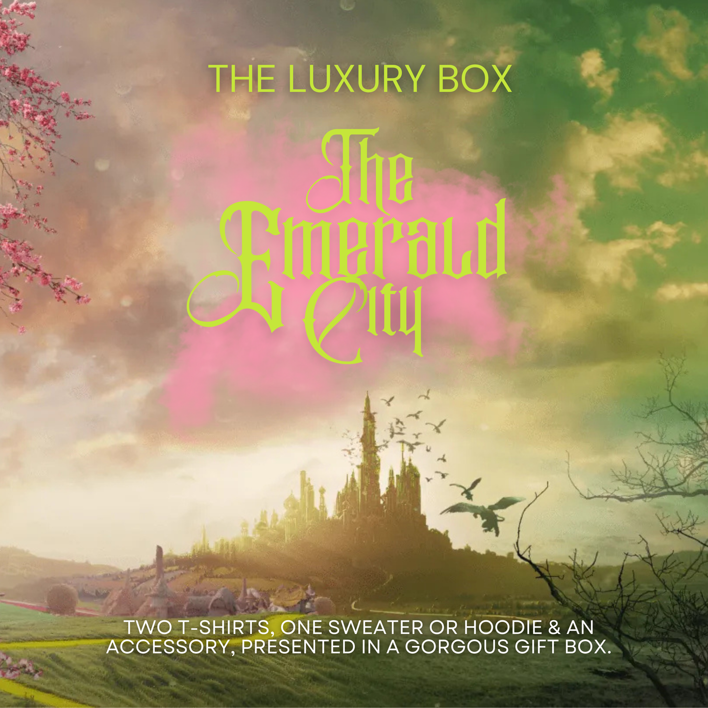 Emerald City themed promotional graphic featuring a fantasy castle in the distance, pink and green magical clouds, and ornate yellow lettering reading ‘The Emerald City – The Luxury Box’. Text describes the contents: two T-shirts, one sweater or hoodie, and an accessory in a gift box
