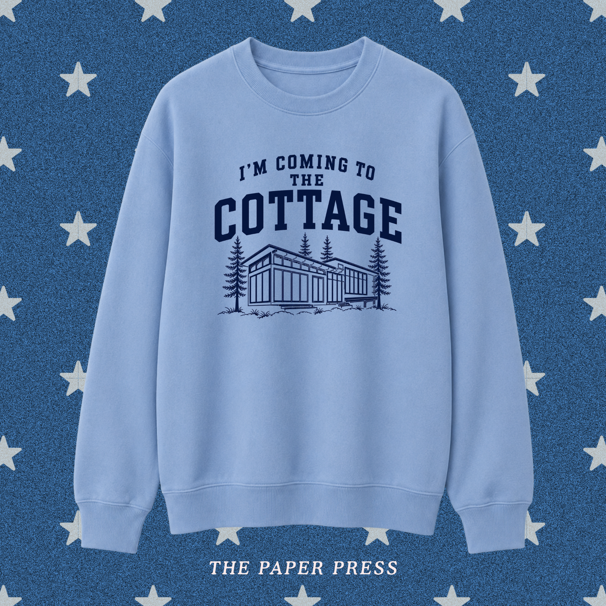 Heated Rivalry coded sweatshirt featuring “I’m Coming to the Cottage” collegiate-style text with a detailed cottage and pine tree illustration, hand-printed by The Paper Press.