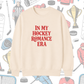 Beige sweatshirt with 'In My Hockey Romance Era' text on a hockey-themed background