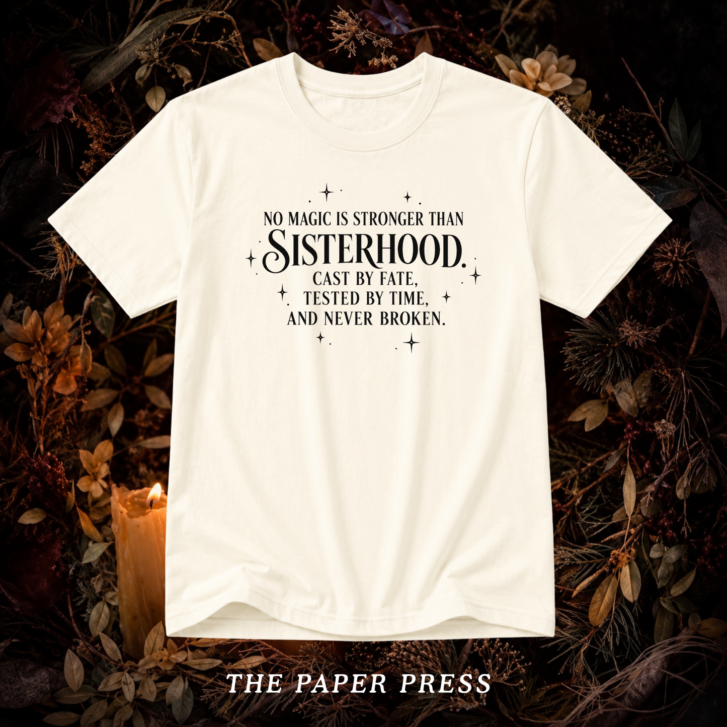 An off-white short-sleeve graphic t-shirt with black text reading 'NO MAGIC IS STRONGER THAN Sisterhood. Cast by fate, tested by time, and never broken.