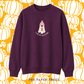 A dark purple crewneck sweatshirt featuring a cartoon ghost wearing a pink beanie with the text 'I AM AN AUTUMN' underneath. The sweatshirt is displayed against a yellow and white pumpkin patterned background with 'THE PAPER PRESS' text at the bottom.