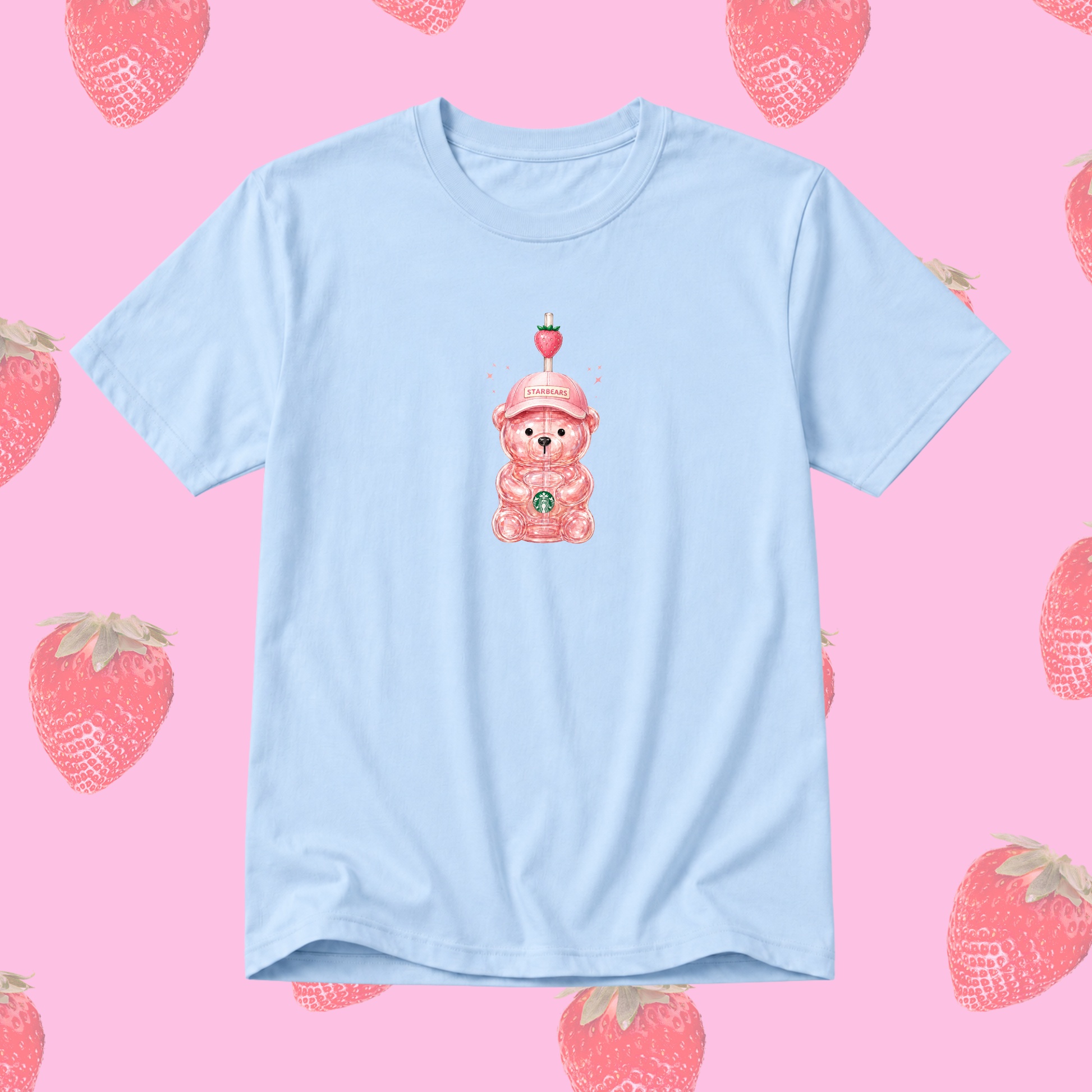 A light blue short-sleeve t-shirt featuring a cute pink cartoon teddy bear wearing a strawberry hat in the center. The t-shirt is displayed flat against a pink background patterned with illustrated strawberries.