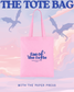 Pink tote bag with 'fae of the foyle' logo against a pastel sky with dragons