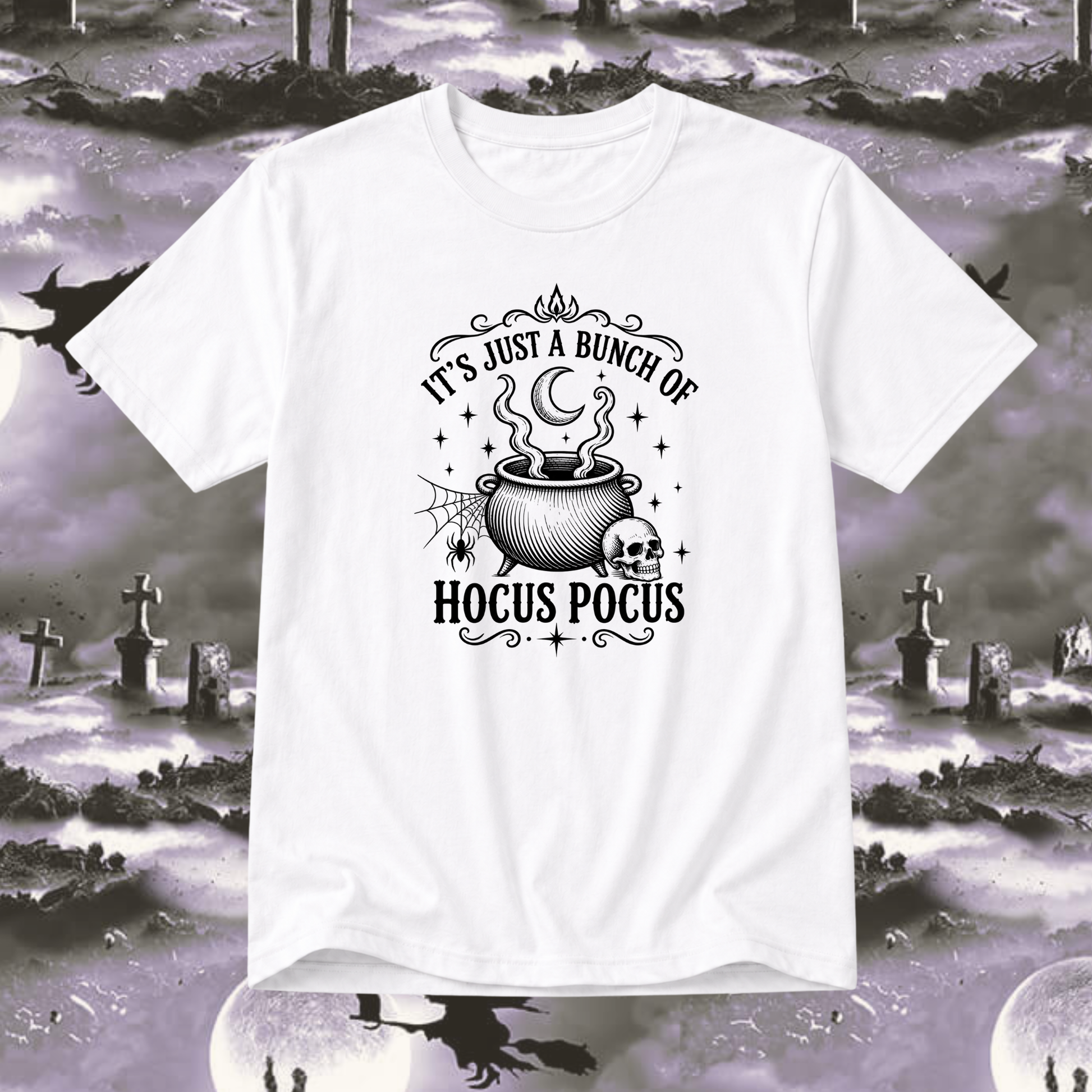A white short-sleeve crewneck t-shirt with a black graphic print reading 'IT'S JUST A BUNCH OF HOCUS POCUS' around an illustration of a cauldron, skull, spiderwebs, and stars. The shirt is displayed against a spooky, desaturated graveyard background with silhouettes of witches on broomsticks and tombstones.