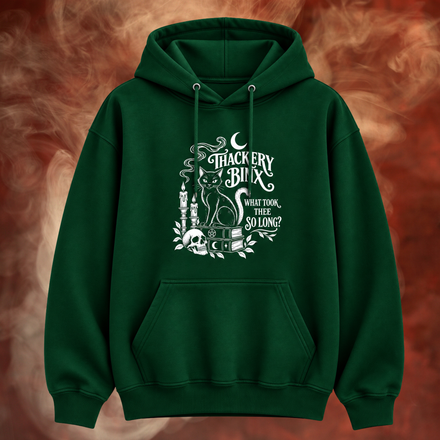 A dark green pullover hoodie with a white gothic graphic on the front featuring a cat, skull, candles, and the text 'TRACKERY BUNN WHAT TOOK THEY SO LONG?'. The hoodie is displayed against a smoky, fiery red and orange background.