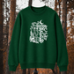 A dark green crewneck sweatshirt with a white graphic print featuring a cat, skull, and the text 'THACKERY BINX WHAT TOOL THEY SELLING?' displayed against a blurred autumn forest background.