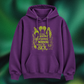 A purple pullover hoodie with a green graphic print on the front, featuring the text 'oh look another glorious MORNING makes me SICK' with witch illustrations, shown against a dark green textured background.