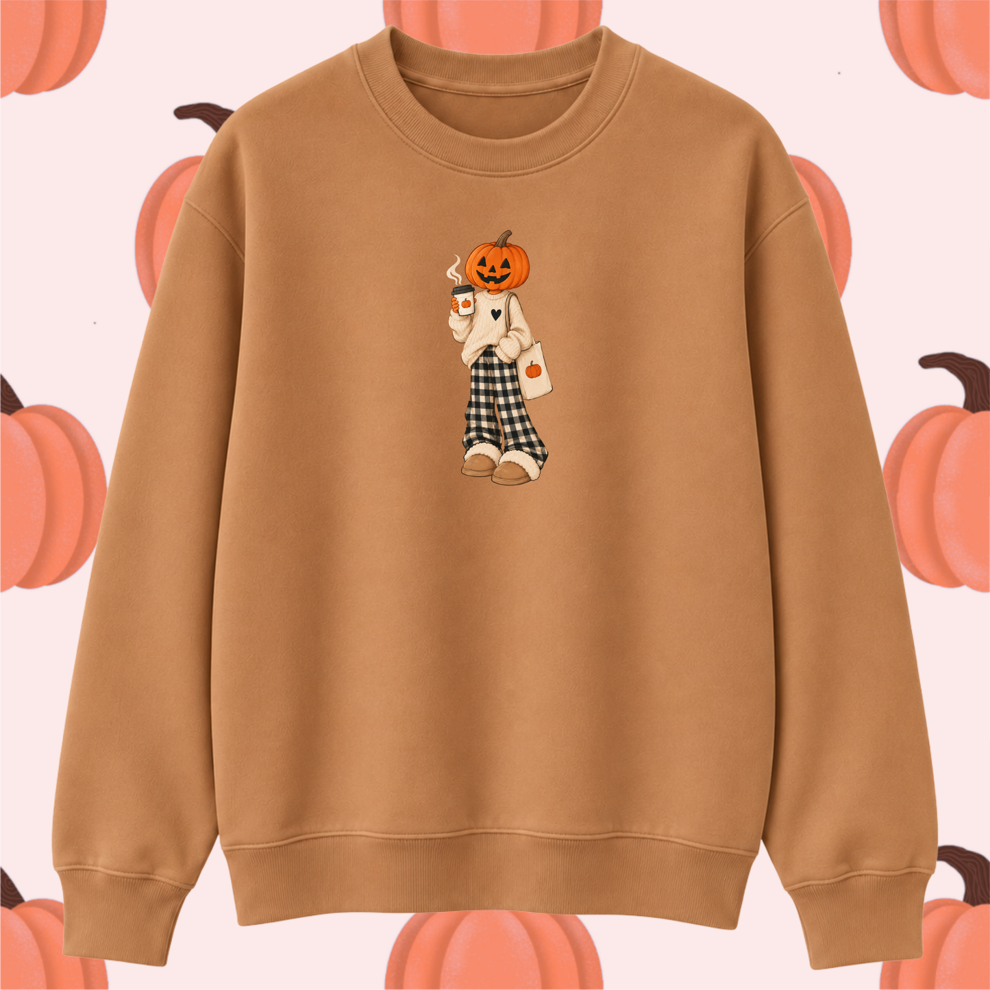 A tan crewneck sweatshirt featuring a central graphic of a scarecrow with a jack-o'-lantern head, set against a light pink background patterned with orange pumpkins.