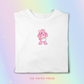 Pink retro bear graphic t-shirt with rainbow belly design on a cotton tee inspired by 90s nostalgia.